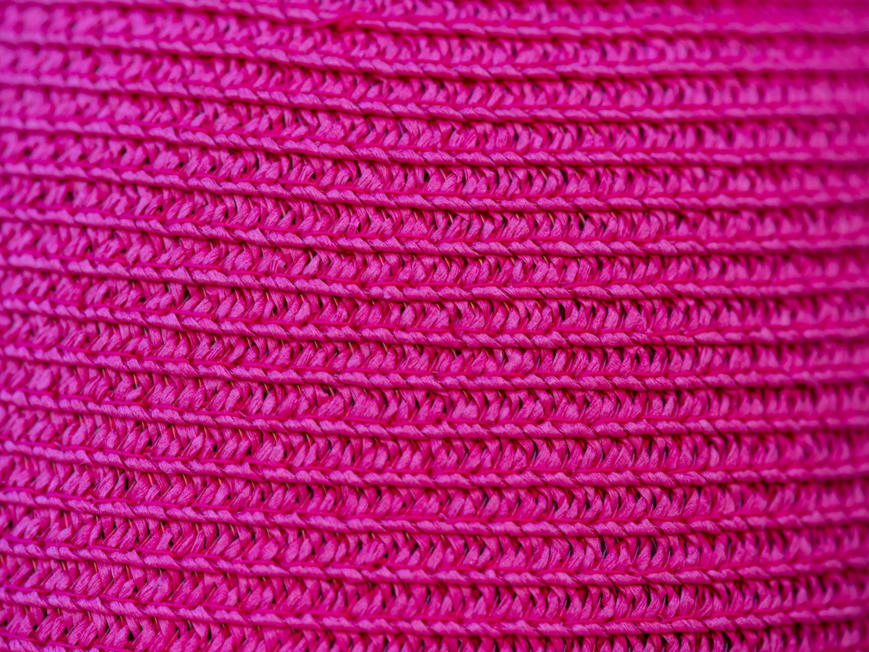 Zbliżenie na różową dzianinę, wyraźna faktura i gęsty splot materiału