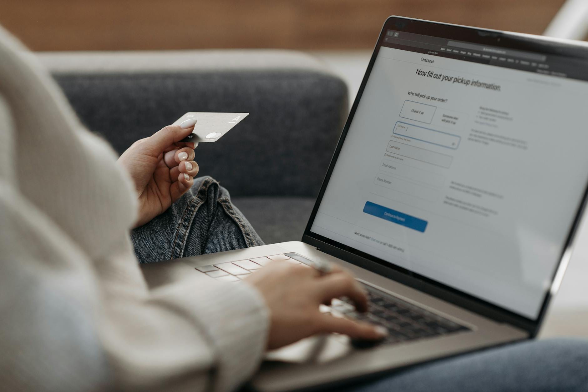 Kobieta na kanapie płaci kartą za zakupy odzieżowe w sklepie online