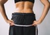 Za ciasne w biodrach, za luźne w pasie? Jak dopasować spodnie do figury klepsydry Osoba mierząca obwód talii miarką krawiecką